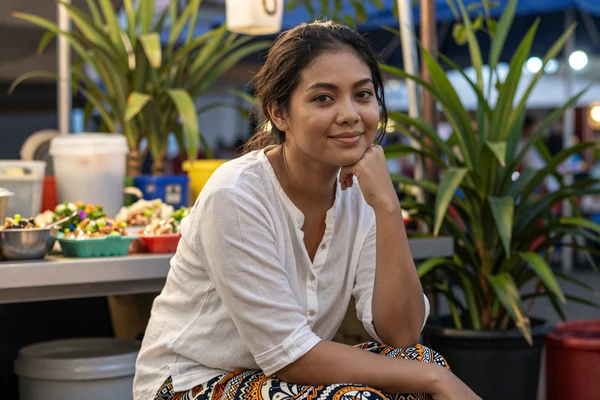 Malaysian woman enjoying evening at a hawker stall with traditional food, showcasing Malaysia's vibrant food culture central to Malaysian women dating