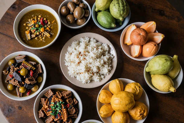 Traditional Filipino feast with adobo, sinigang, and tropical fruits on a wooden table representing Filipino dating culture and cuisine